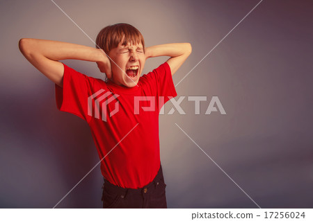 boy teenager European appearance in a red shirt covered his ears 17256024
