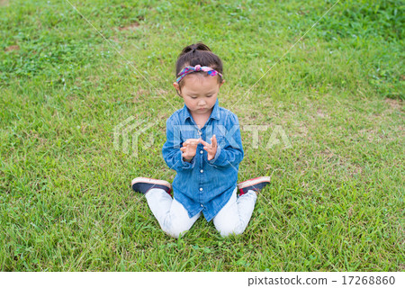 一個女孩坐在草坪上 17268860