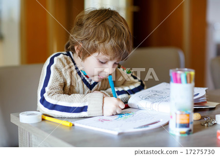 Cute happy schoolkid at home making homework 17275730
