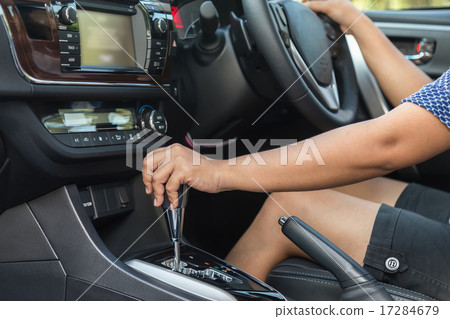 Close up driver left hand shifting the gear stick 17284679