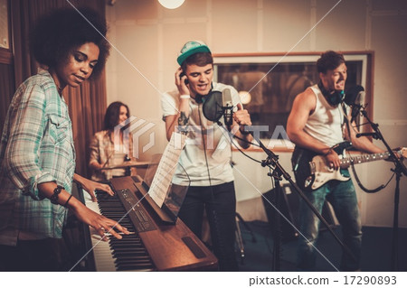 Multiracial music band performing in a recording studio Multiracial music band performing in a recording studio 17290893