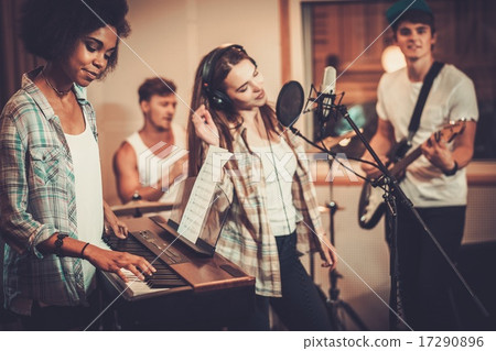 Multiracial music band performing in a recording studio Multiracial music band performing in a recording studio 17290896