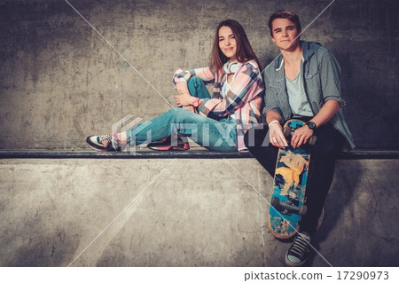 Young couple with skateboard and rollerblades outdoors 17290973