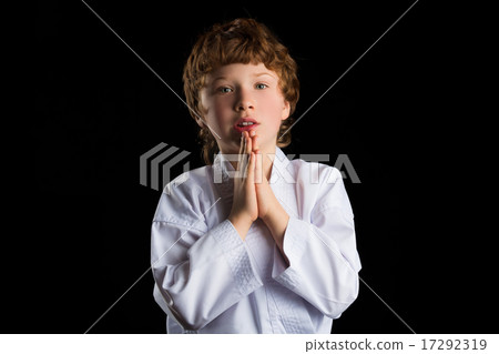 Karate boy in white kimono isolated on black background Karate boy in white kimono isolated on black background 17292319