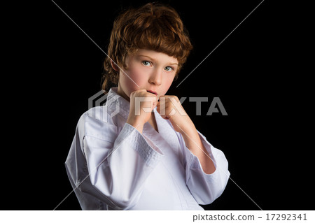 Karate boy in white kimono isolated on black background Karate boy in white kimono isolated on black background 17292341