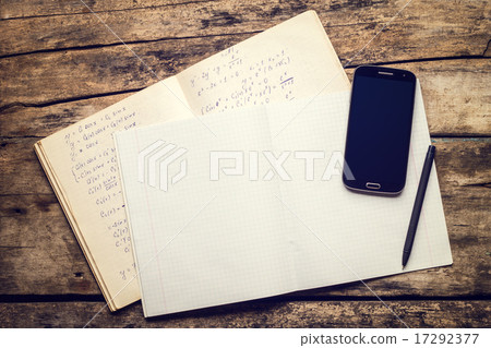 Exercise book with smartphone and pen on old wooden table 17292377