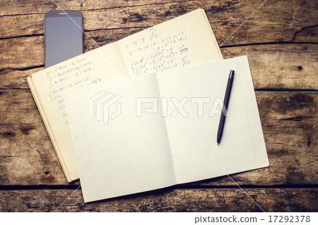 Exercise book with smartphone and pen on old wooden table 17292378