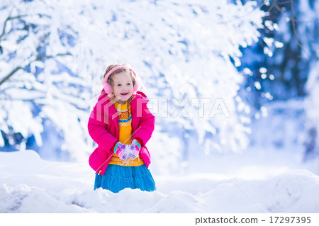 Little girl playing in snowy winter forest 17297395