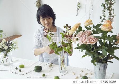 享受花的佈置的婦女 享受花的佈置的婦女 17301086