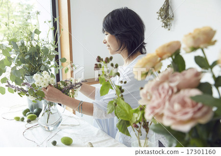 享受花的佈置的婦女 享受花的佈置的婦女 17301160