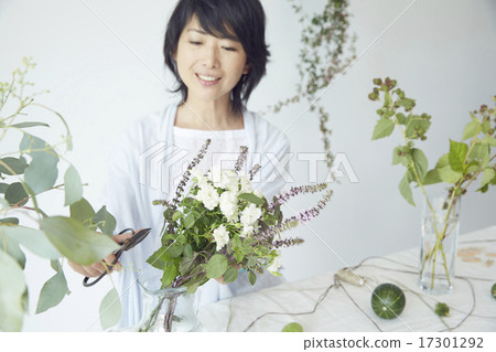 A woman enjoying a flower arrangement 17301292