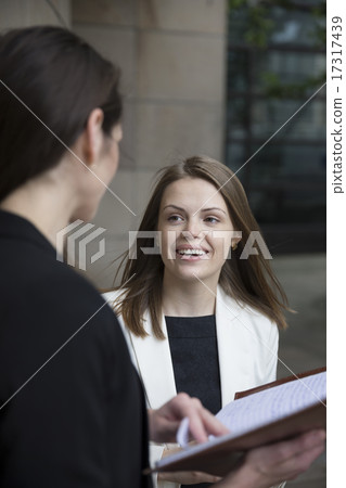 Two happy businesswomen talking 17317439