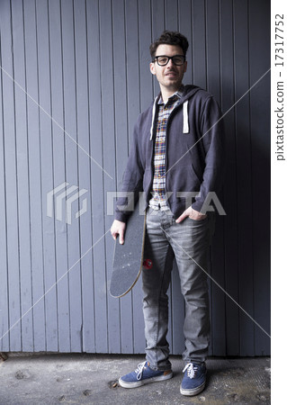 Trendy man holding a skateboard. 17317752