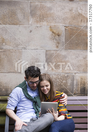 Caucasian couple using a digital tablet outdoors. Caucasian couple using a digital tablet outdoors. 17317760
