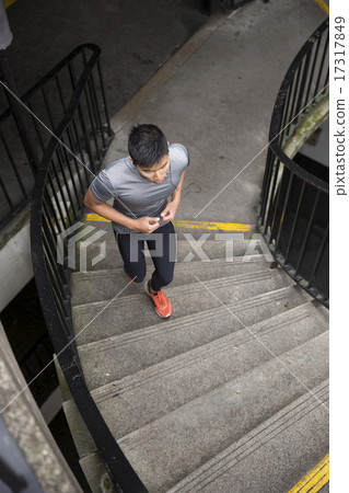 Asian running man, listening to music on smart phone while runni 17317849