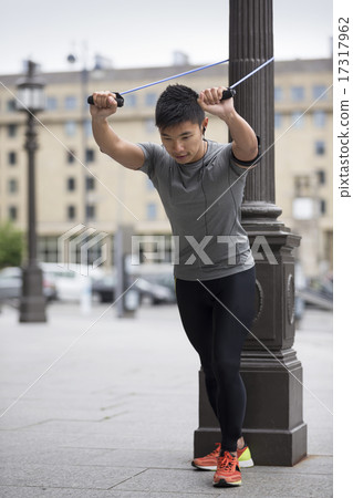 Asian man exercising with resistance band 17317962