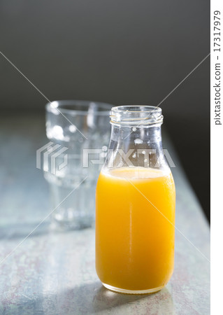 Bottle of Orange juice on a rustic wooden table. 17317979