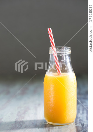 Bottle of Orange juice on a rustic wooden table. 17318055