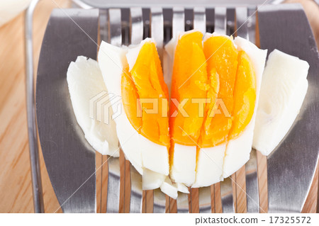 Egg cutter and cutted eggs on wooden table Egg cutter and cutted eggs on wooden table 17325572