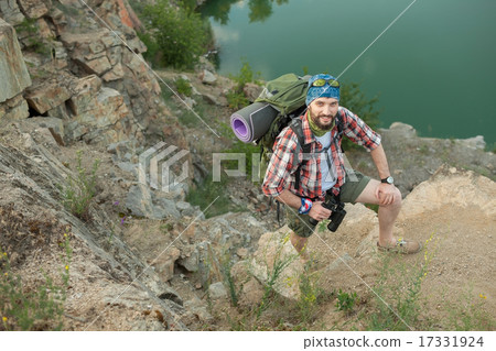 Young caucasian man with backpack climbing the rock 17331924