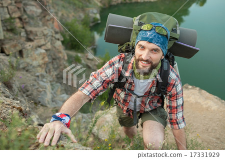 Young caucasian man with backpack climbing the rock Young caucasian man with backpack climbing the rock 17331929