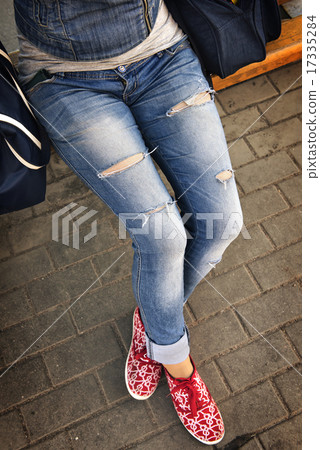 girl in ripped jeans sitting on the bench 17335284