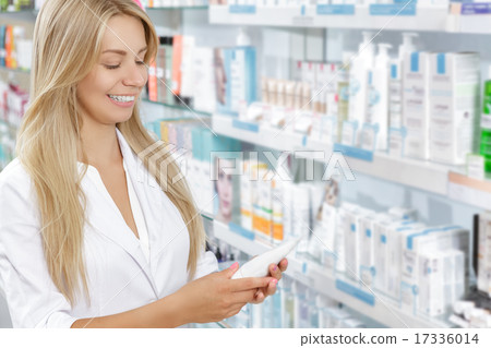 Beautiful pharmacist choosing the product in drugstore 17336014