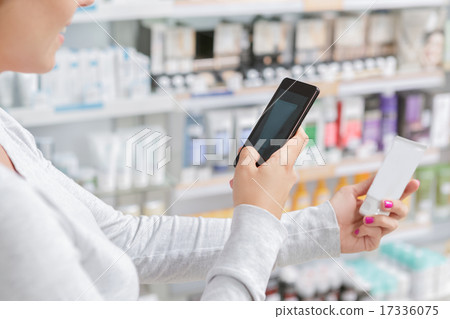 Close up a woman taking picture of product in drugstore 17336075