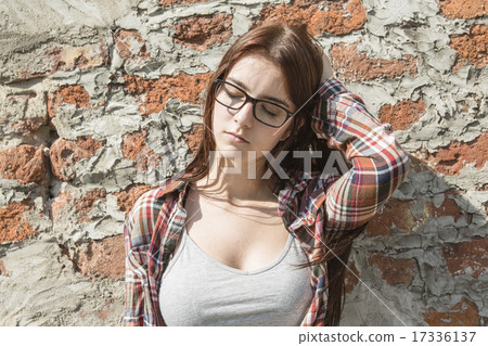 Stunning young woman posing outdoor over brick wall. 17336137