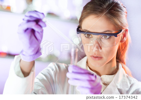 Young scientist pipetting in life science laboratory. Young scientist pipetting in life science laboratory. 17374342