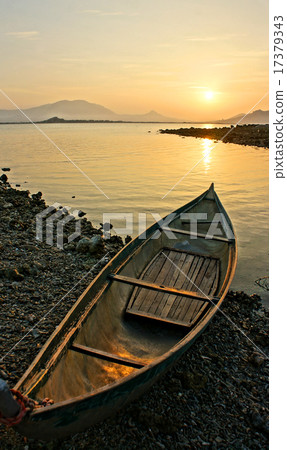 Lonely boat looking toward the sun Lonely boat looking toward the sun 17379343