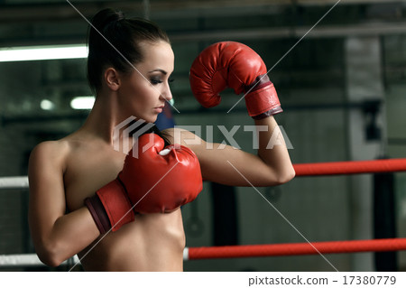 Pretty naked female boxer looks at her biceps Pretty naked female boxer looks at her biceps 17380779