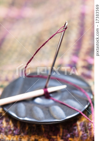 attaching of button to woolen material by needle attaching of button to woolen material by needle 17383569