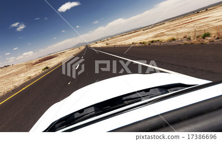 Car drive through empty desert road 17386696