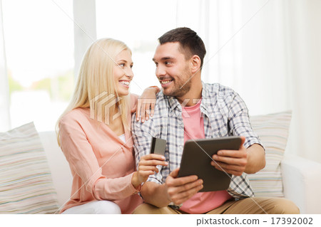 happy couple with tablet pc and credit card 17392002