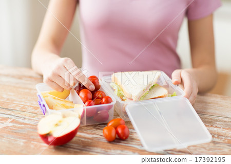 close up of woman with food in plastic container close up of woman with food in plastic container 17392195