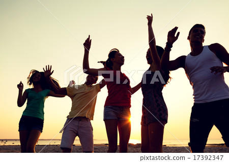 smiling friends dancing on summer beach smiling friends dancing on summer beach 17392347