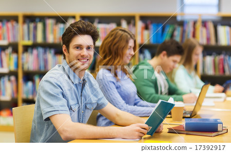 happy student boy reading books in library happy student boy reading books in library 17392917