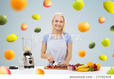 smiling woman with blender preparing fruit shake 17392926