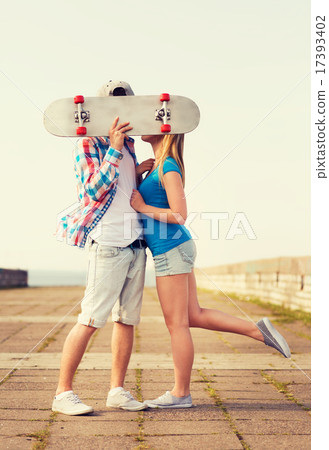 couple with skateboard kissing outdoors couple with skateboard kissing outdoors 17393402