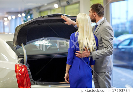 happy couple choosing car in auto show or salon 17393784