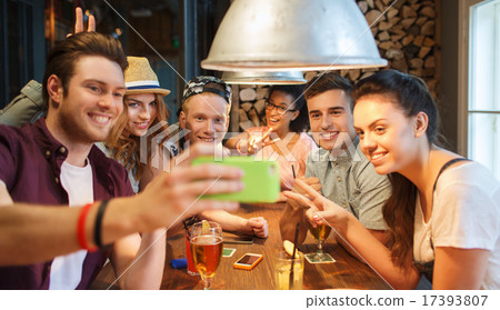 happy friends with smartphone taking selfie at bar 17393807