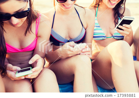 close up of friends with smartphones on beach close up of friends with smartphones on beach 17393881