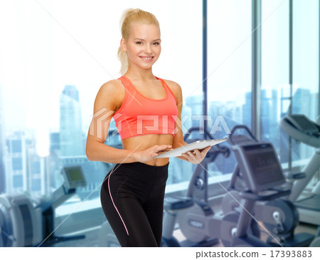 smiling sporty woman with tablet pc in gym smiling sporty woman with tablet pc in gym 17393883