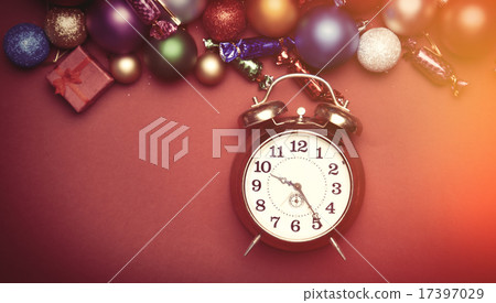 Alarm clock and christmas toys on red table. Alarm clock and christmas toys on red table. 17397029
