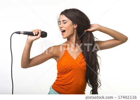Pretty lady in orange shirt with microphone. 17402116