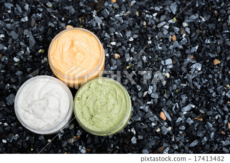 Group of cream on dark blue pebbles background 17413482