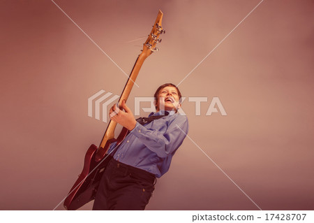 teenager boy brown hair of European appearance playing guitar fe 17428707
