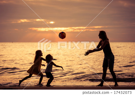 Mother and children playing on the beach at the sunset time. 17432073