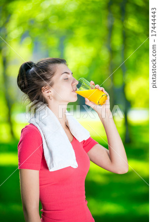 Woman drinking fresh orange juice Woman drinking fresh orange juice 17444443
